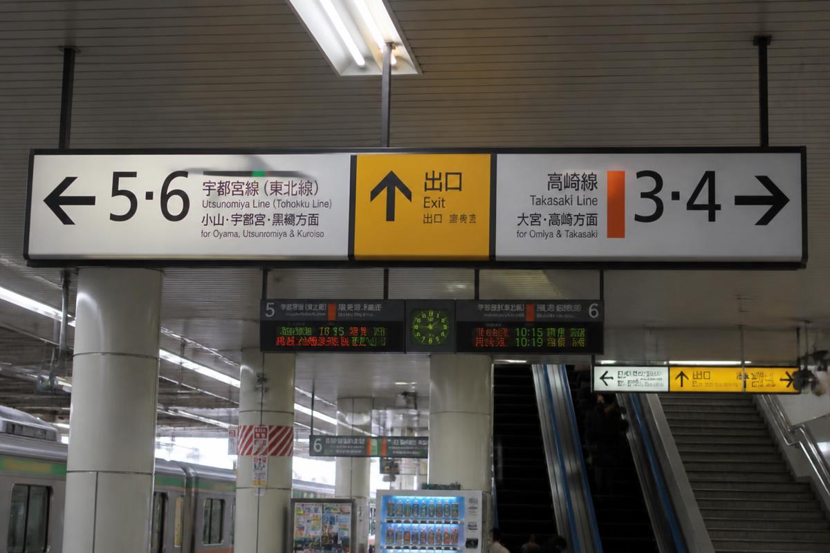 Overhead station signage showing platform numbers with directional arrows